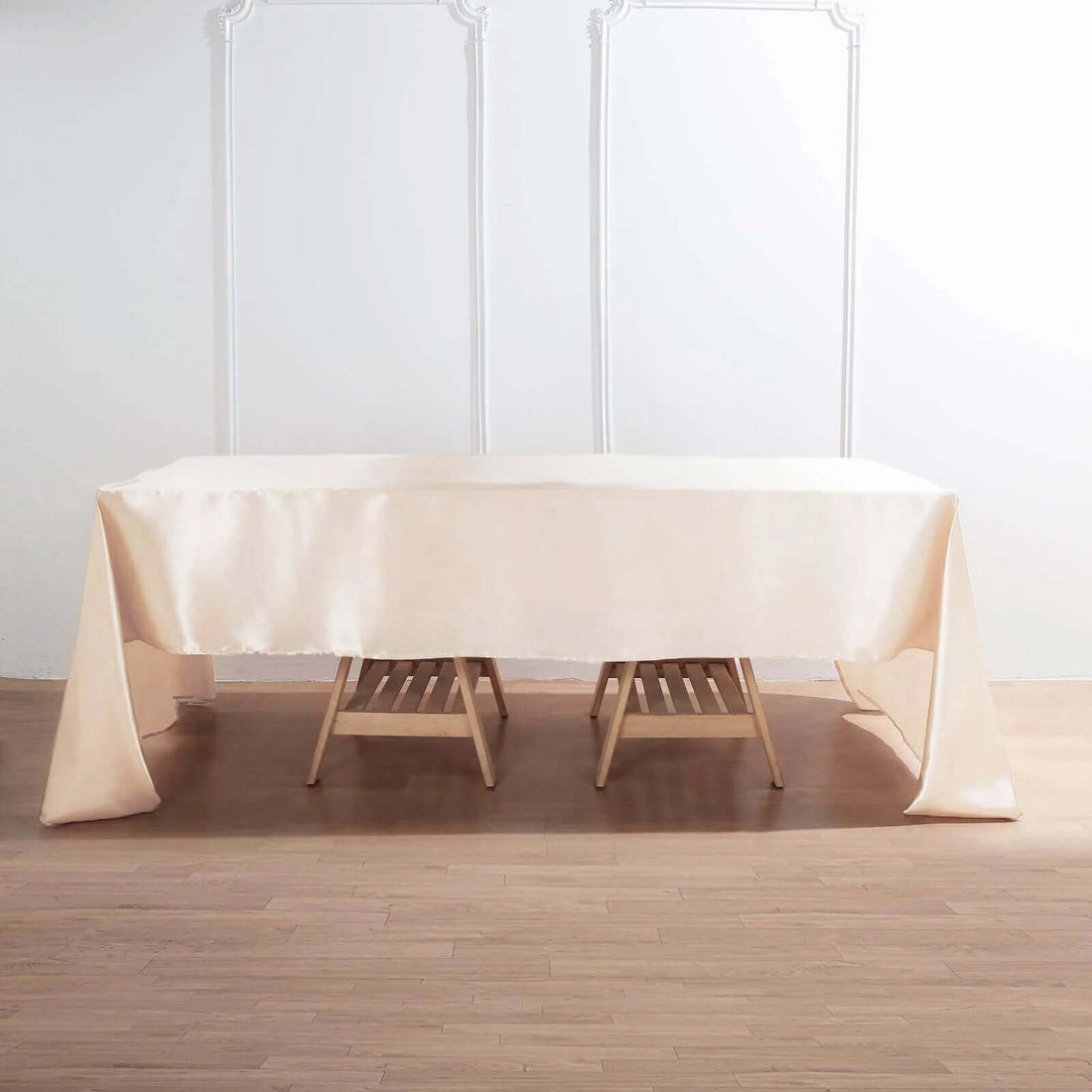 Beige tablecloth draped over a wooden table in a minimalist setting.