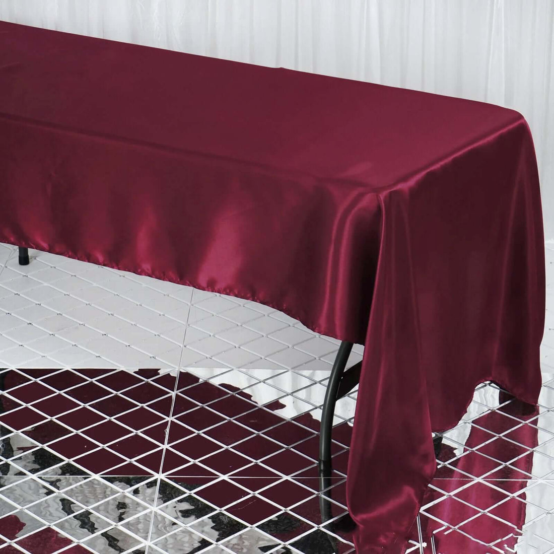 Burgundy satin tablecloth draping elegantly over a table