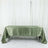 Green satin tablecloth draped over a table against a plain background.