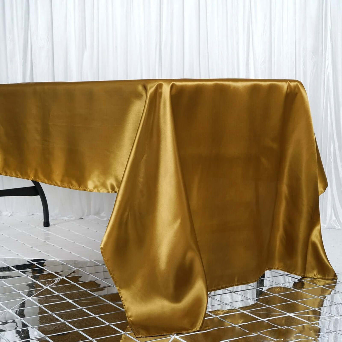 Gold satin tablecloth draped elegantly over a table.
