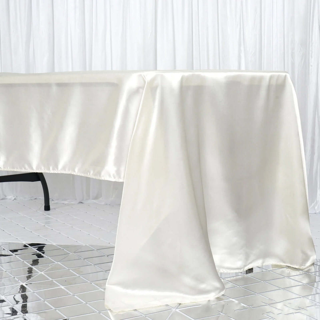 Ivory satin tablecloth draping elegantly over a table