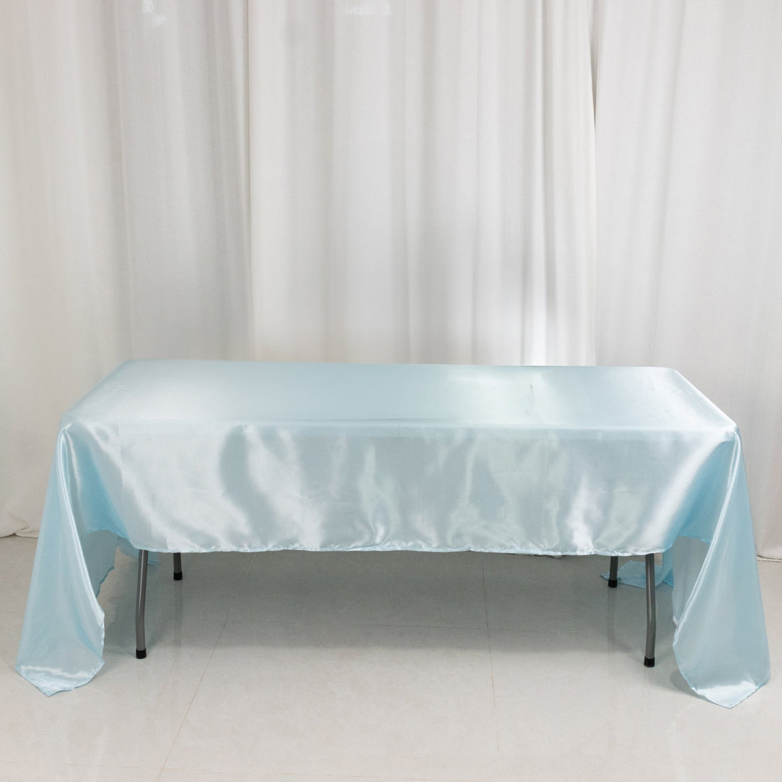 Light blue satin tablecloth on a table, elegantly draped.