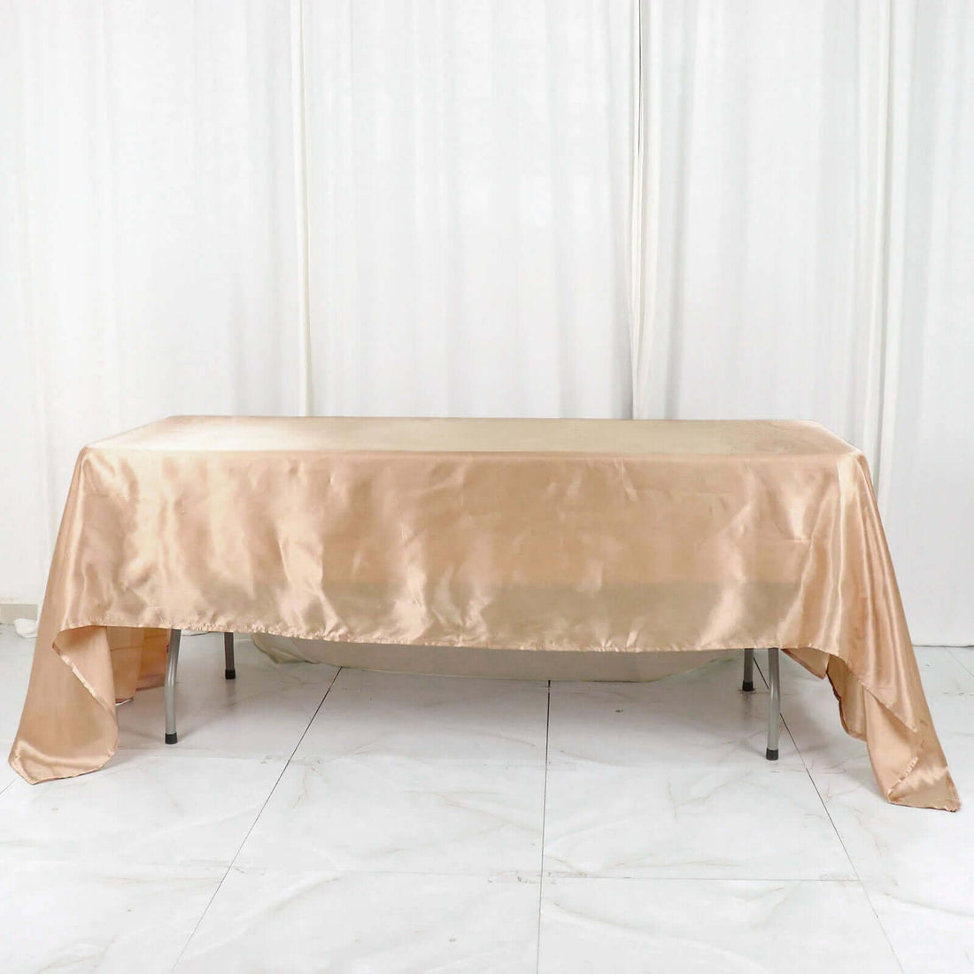Satin tablecloth in blush pink draped over a table