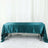 Teal satin tablecloth draped over a table in a studio setting.