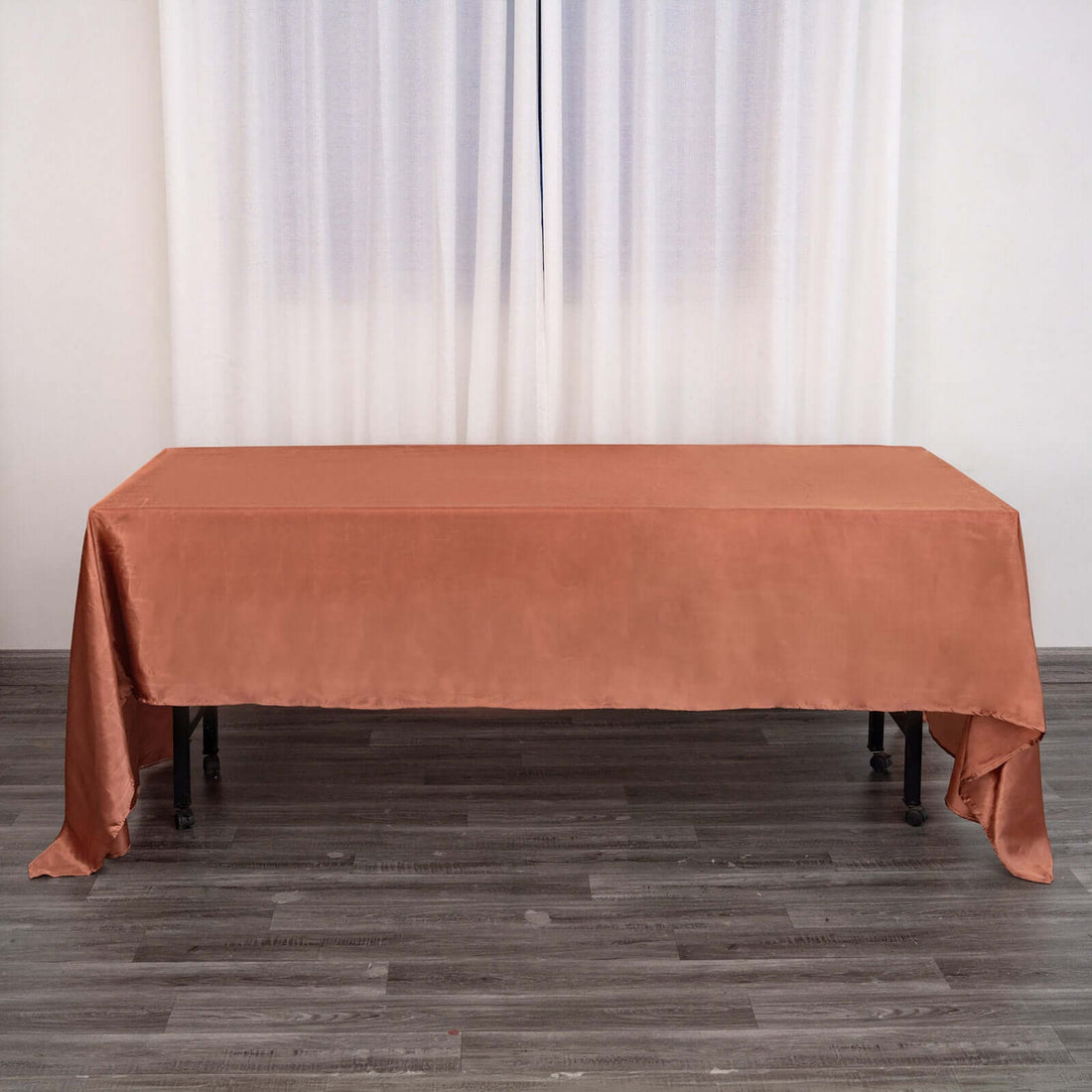 Rust-colored tablecloth draped over a table in a studio setting.