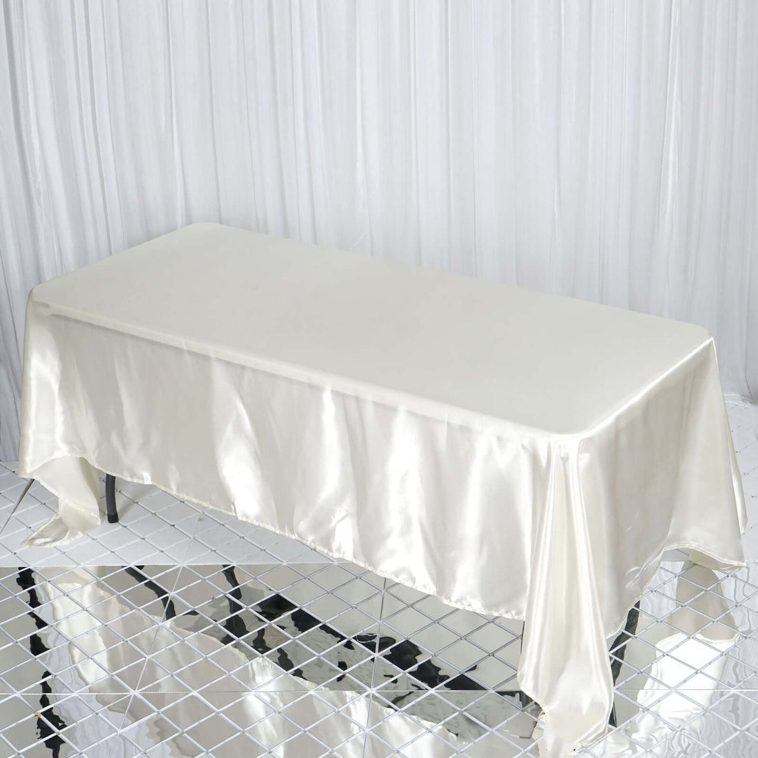 Elegant cream satin tablecloth on a rectangular table.