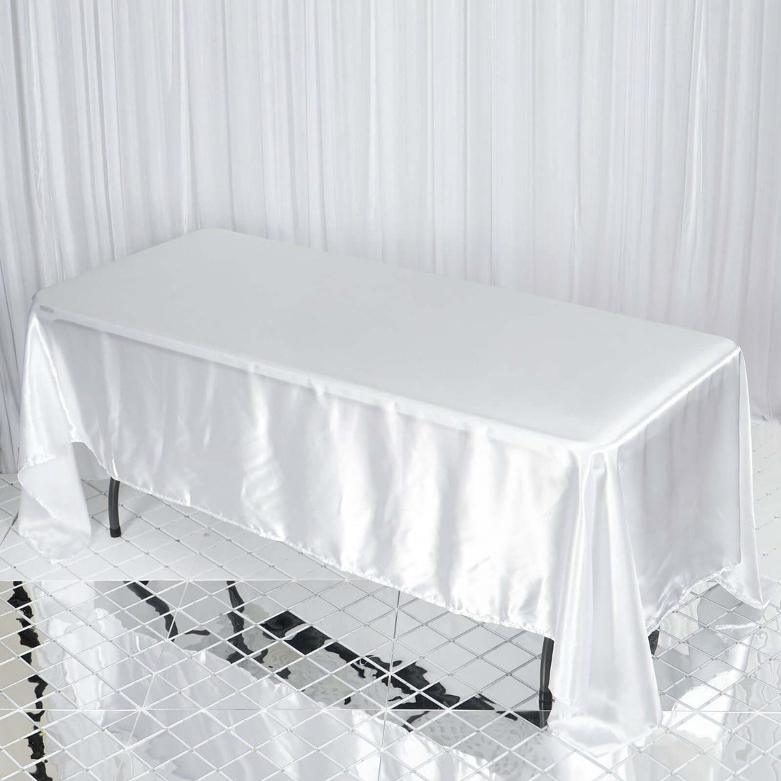 White satin tablecloth draped over a rectangular table