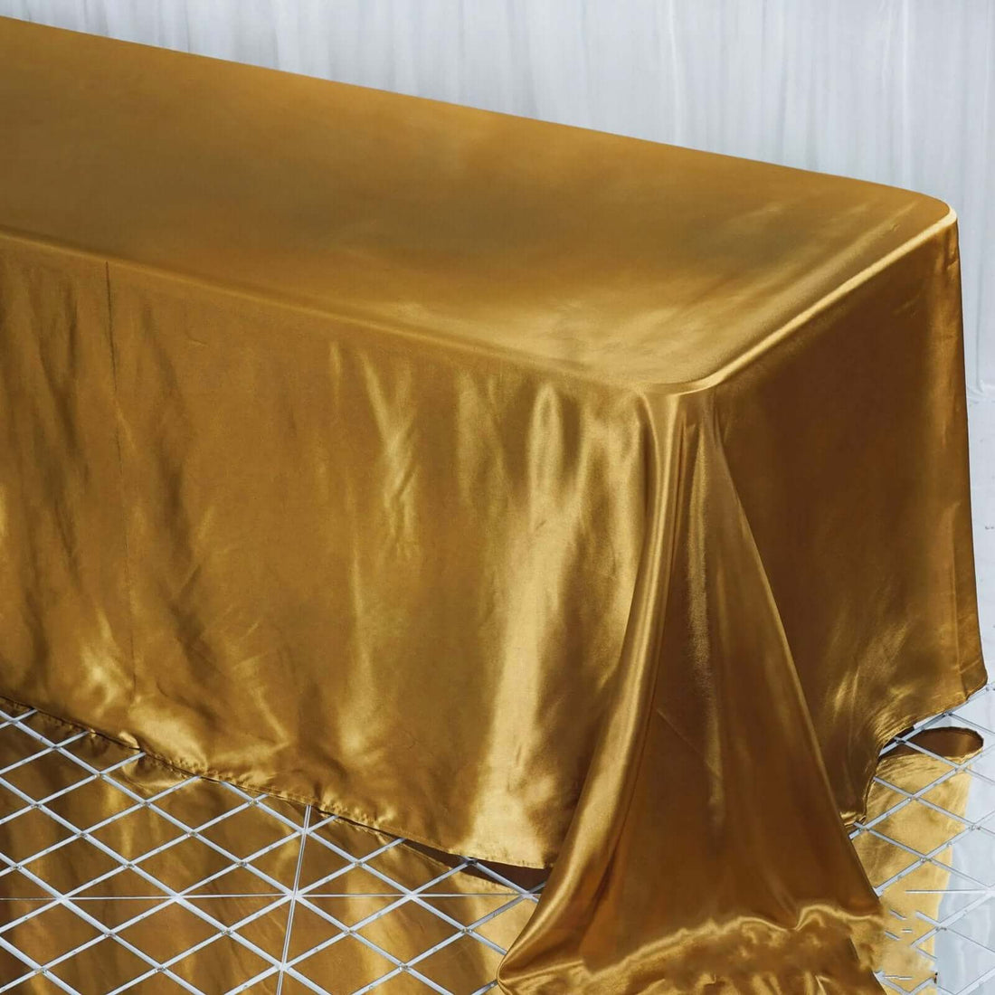 Gold satin tablecloth draping over a table
