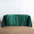 Green satin tablecloth on wooden floor, elegantly draping over a table.