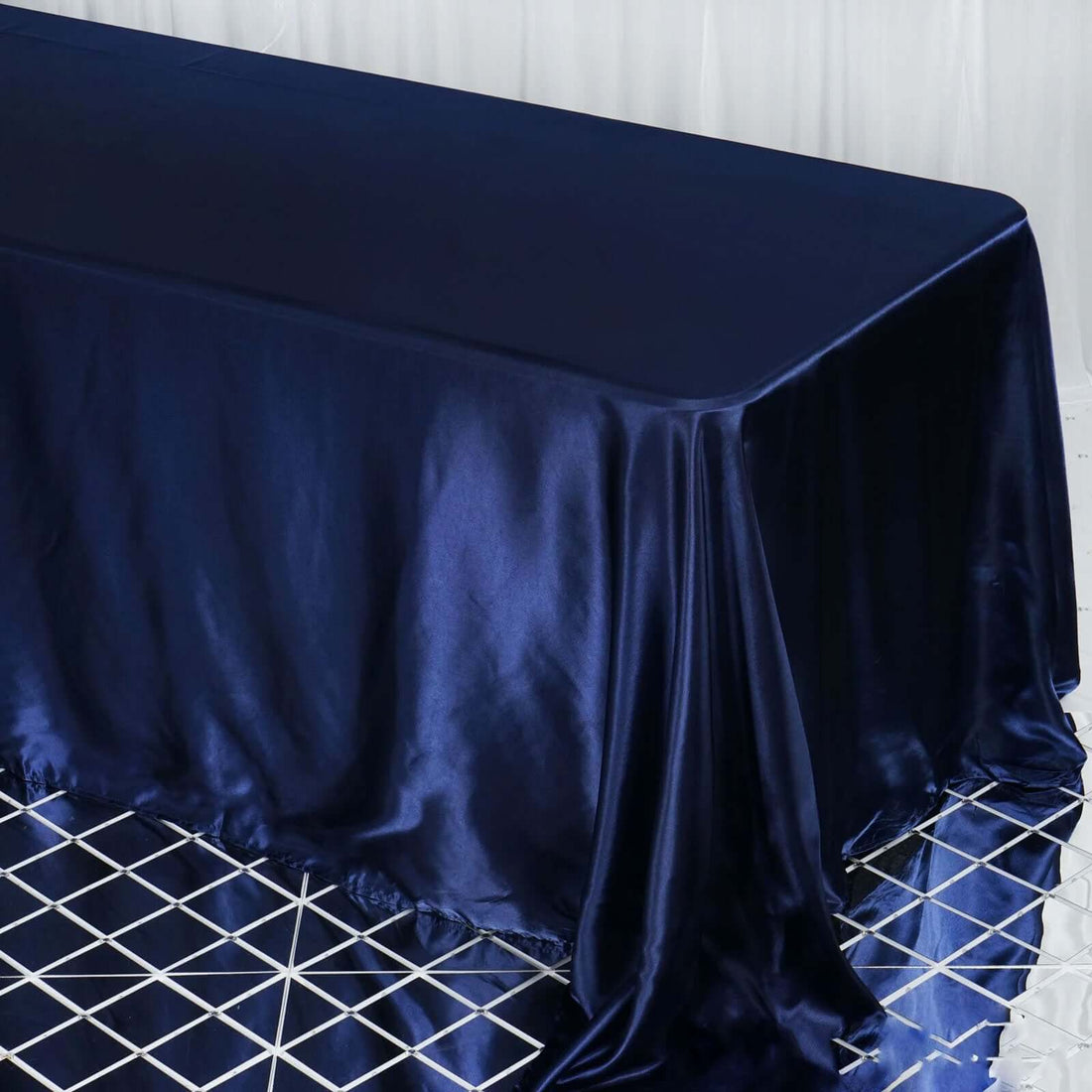Navy satin tablecloth draped elegantly on a geometric patterned table