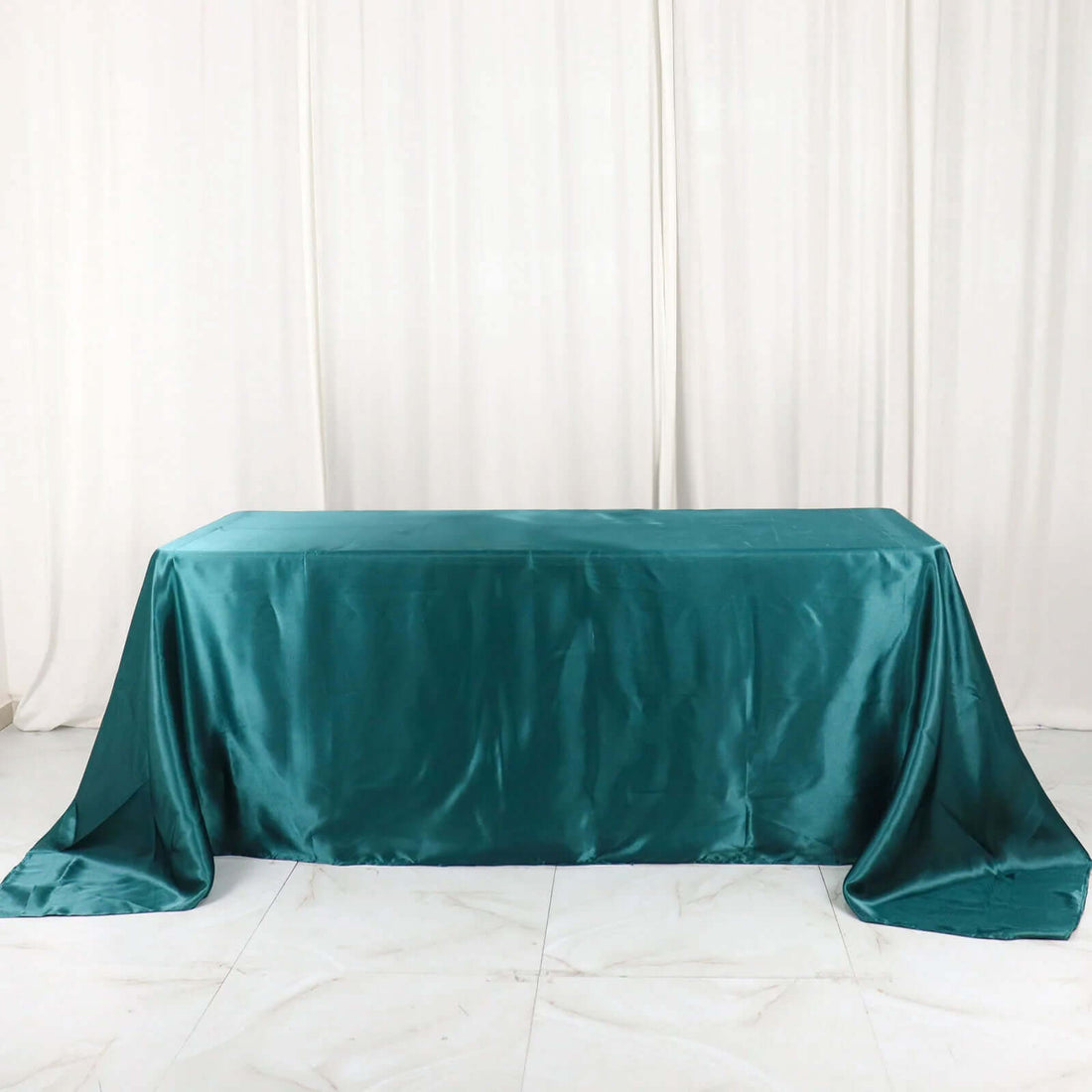 Teal satin tablecloth draped elegantly over a table