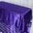 Purple satin tablecloth on a reflective surface.