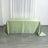 Green satin tablecloth draped over a table in a bright room.