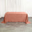 Rose satin tablecloth on a wooden floor with curtains in the background.