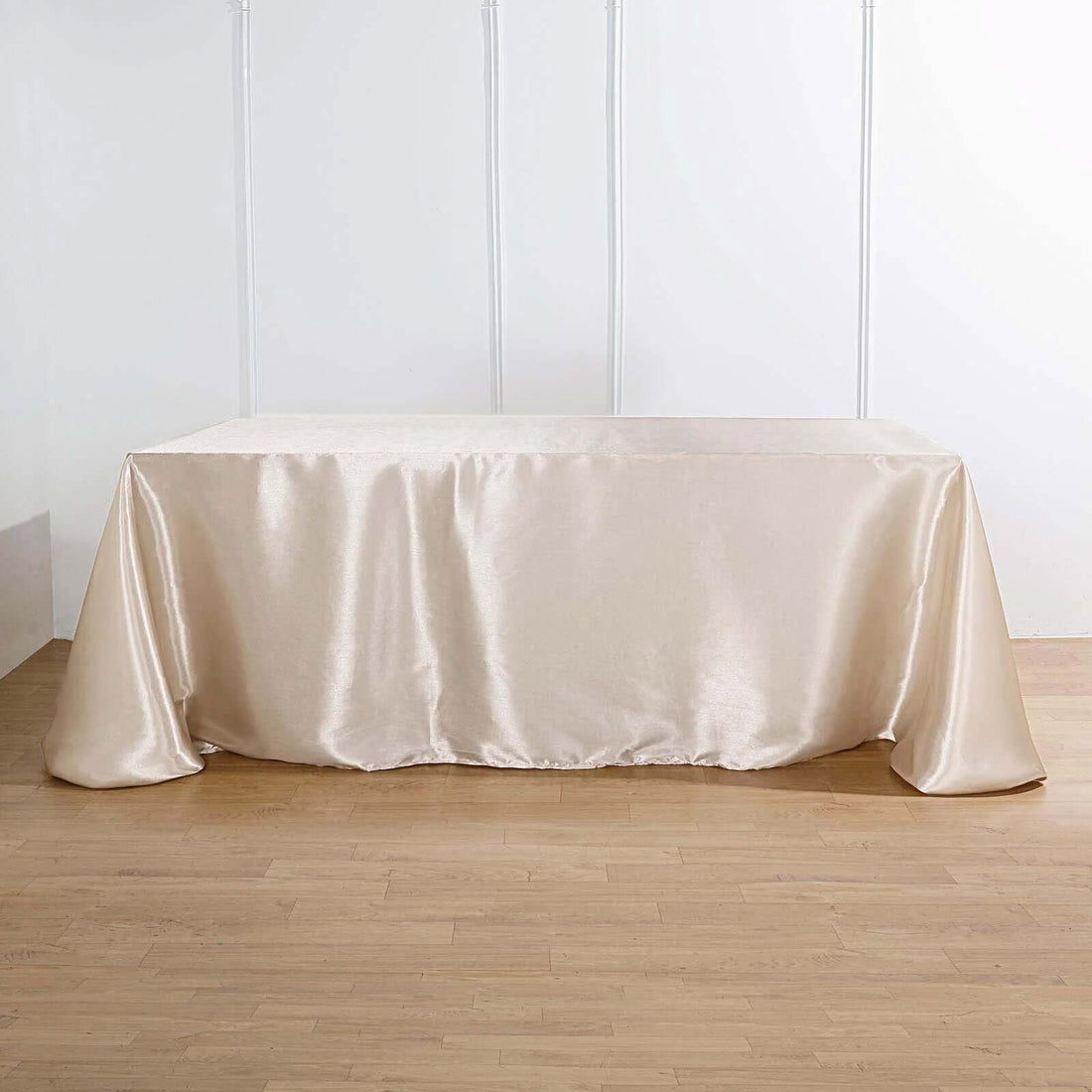 Elegant beige satin tablecloth on a smooth wooden surface