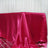 Shiny pink satin tablecloth draped elegantly over a table.
