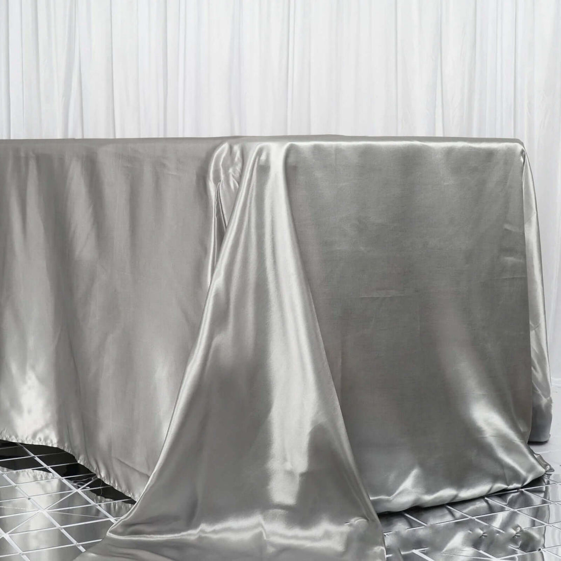 Silver satin tablecloth draped elegantly on a table.