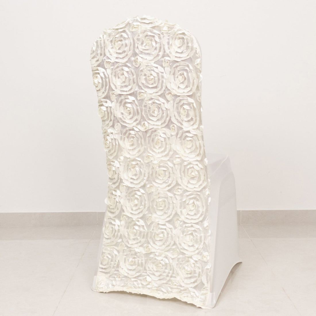 White chair with rose-patterned backrest on a plain backdrop.