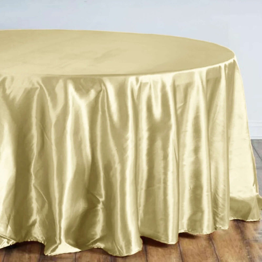 Gold satin tablecloth draping over a round table.