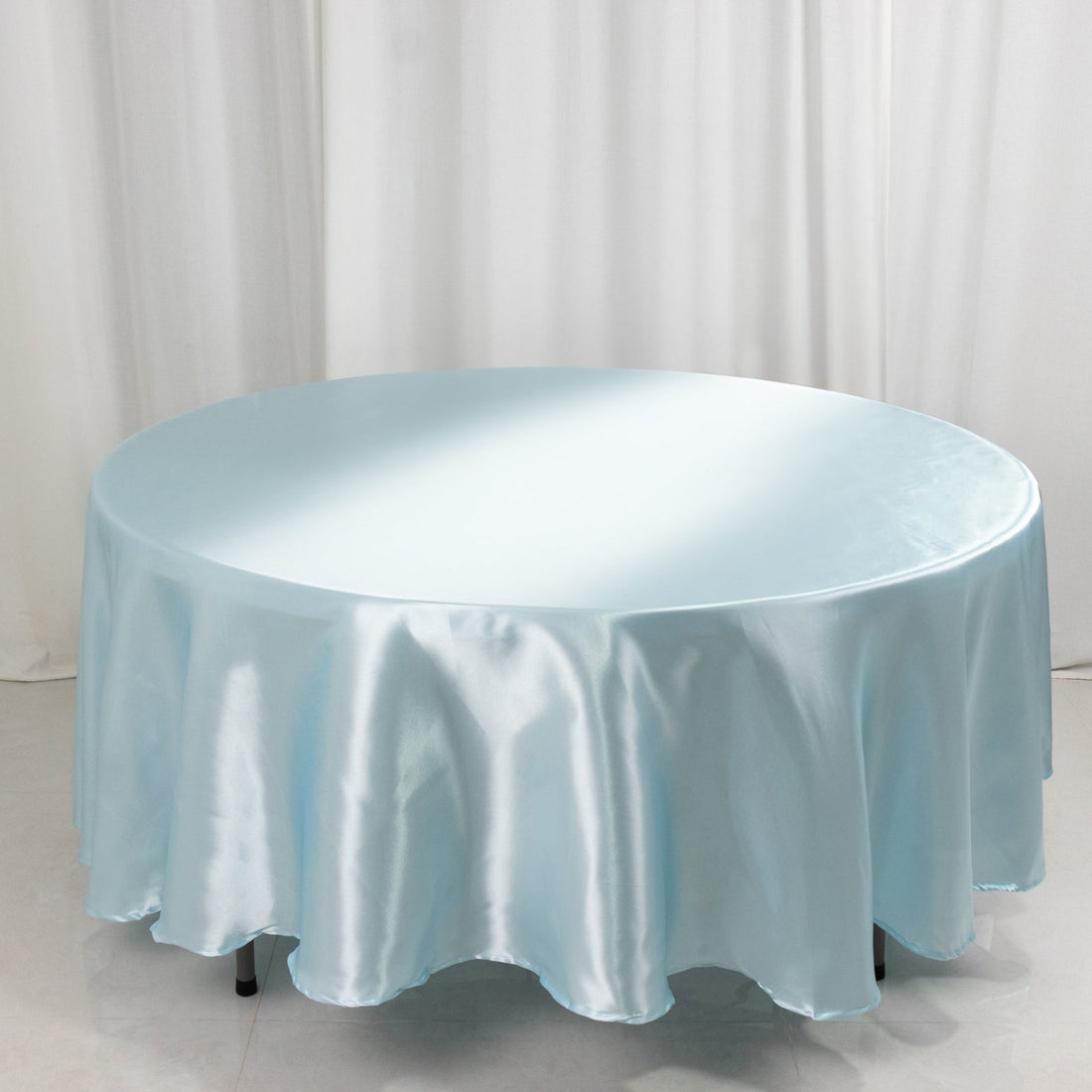 Light blue satin tablecloth draped over a round table