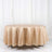 Beige satin tablecloth on a round table against a plain white backdrop