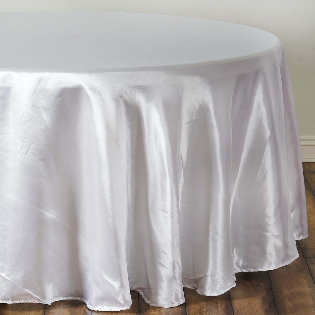 White satin tablecloth draping elegantly over a round table.