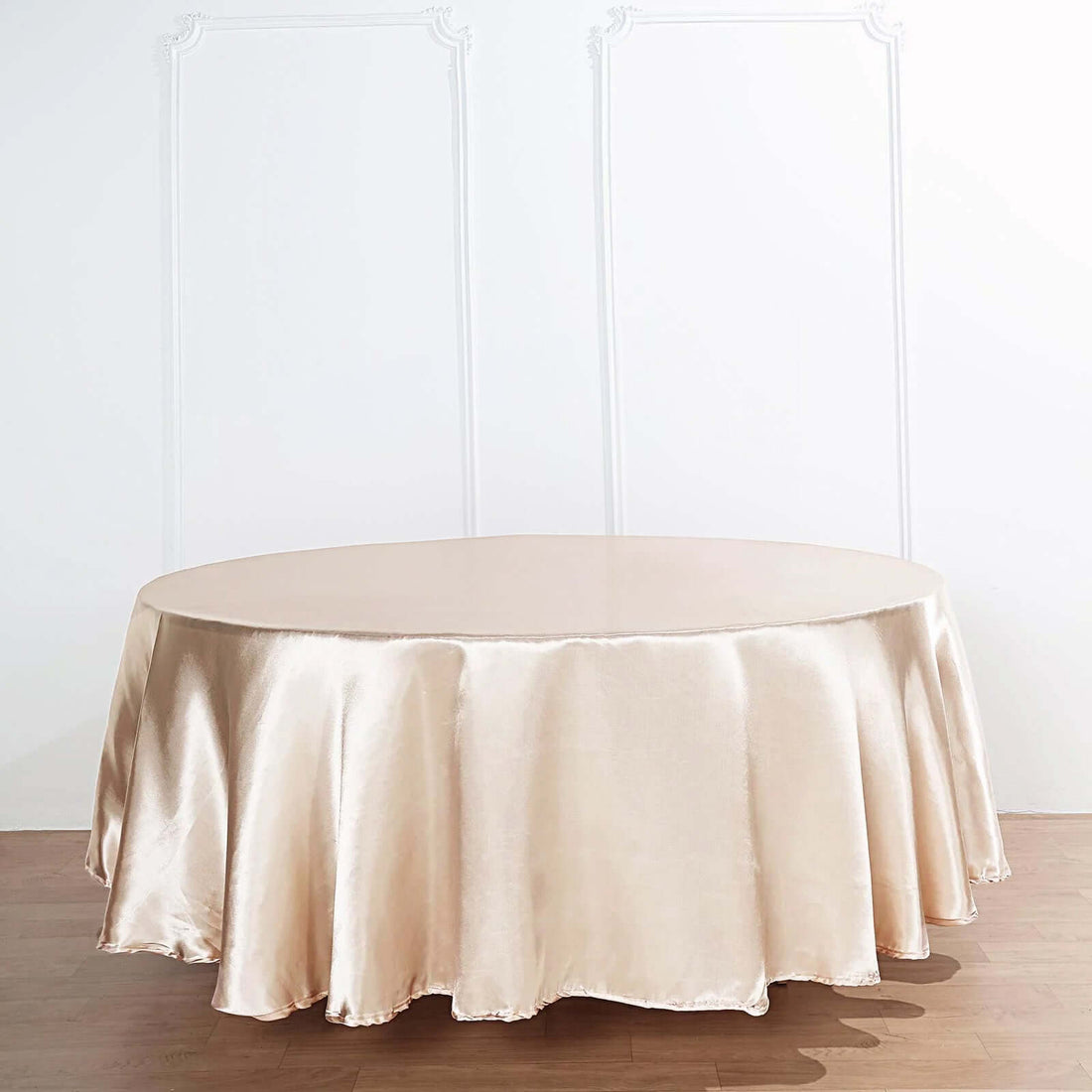 Round satin tablecloth in champagne color on a plain background