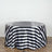 Black and white striped tablecloth draped over a round table.