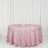 Pink rose-patterned tablecloth on a round table against a white backdrop.