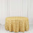 Gold rose-patterned tablecloth on a round table against a white backdrop.