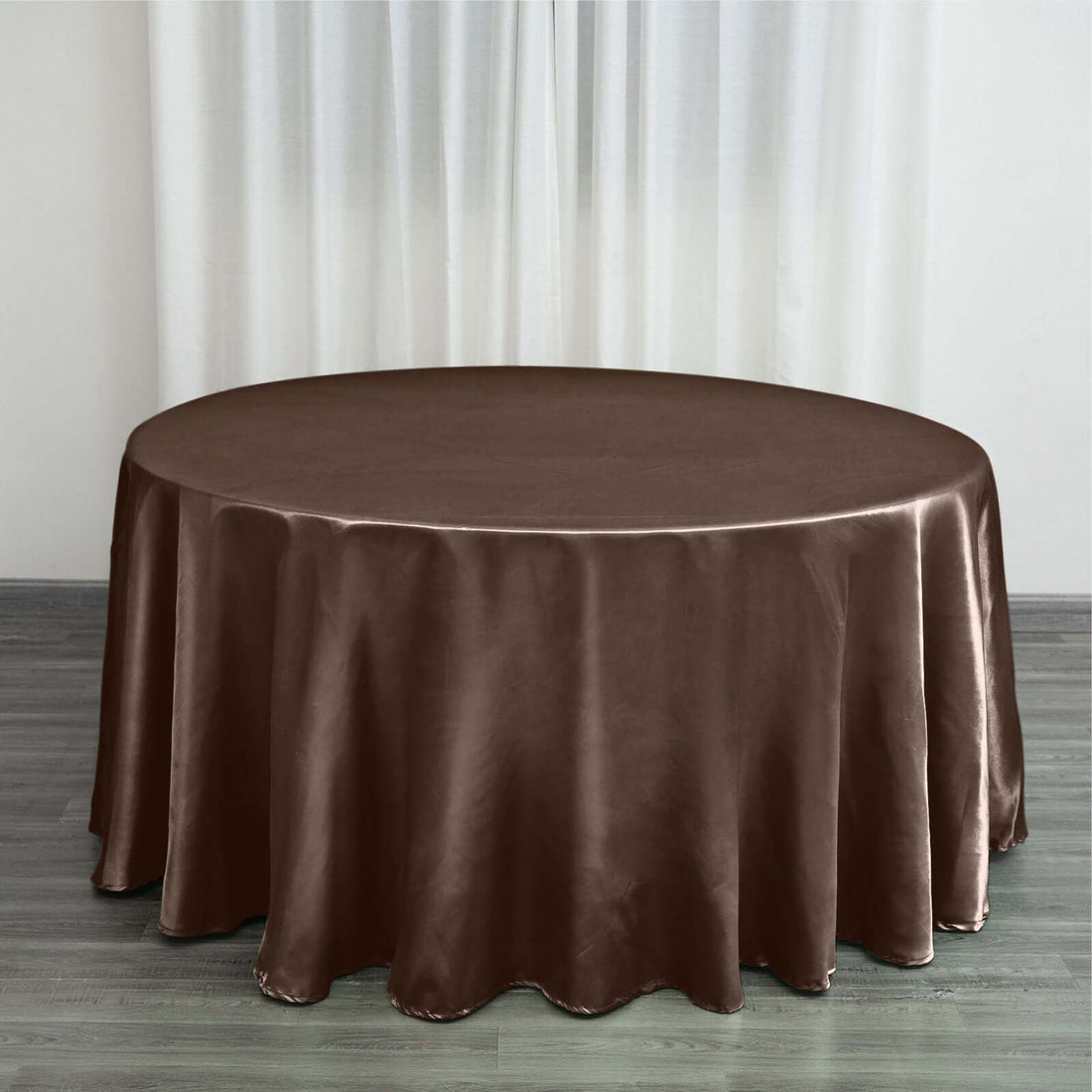 Brown satin round tablecloth on a wooden floor.