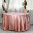Pink satin tablecloth draped elegantly on a round table.