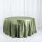 Olive green satin tablecloth on a round table against a plain backdrop