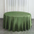 Green satin round tablecloth on a wooden floor with curtains in background.