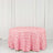 Pink rose-patterned tablecloth on a round table against a white backdrop.