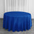 Round blue tablecloth on a wooden floor with white curtains in the background.