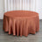 Round copper tablecloth draped on a circular table in a staged setting.
