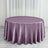 Purple satin round tablecloth on a wooden floor with curtains in the background.