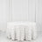 Round white rose-patterned tablecloth on a plain backdrop.