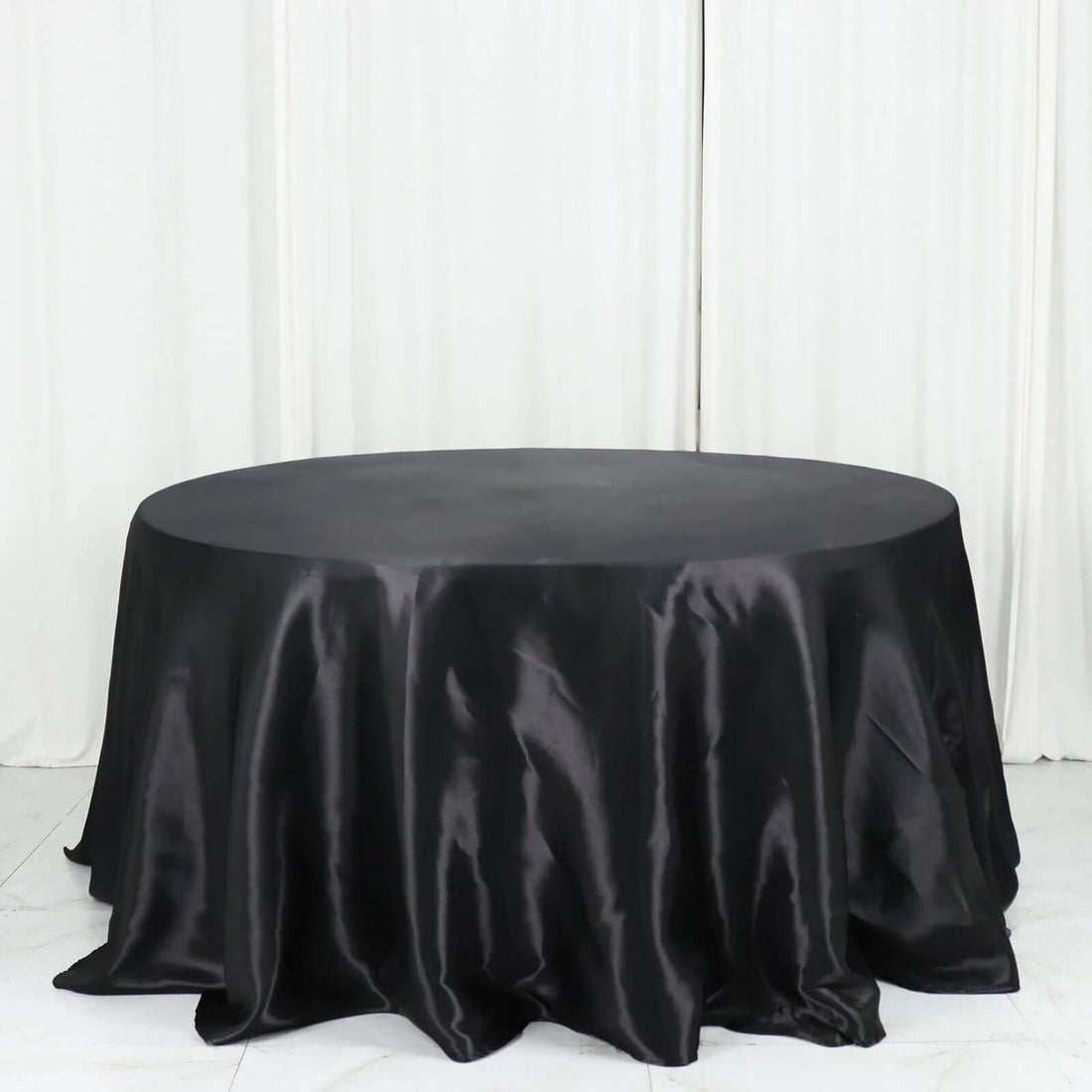 Black satin tablecloth draped elegantly over a round table.