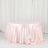Round pink satin tablecloth on a plain backdrop.
