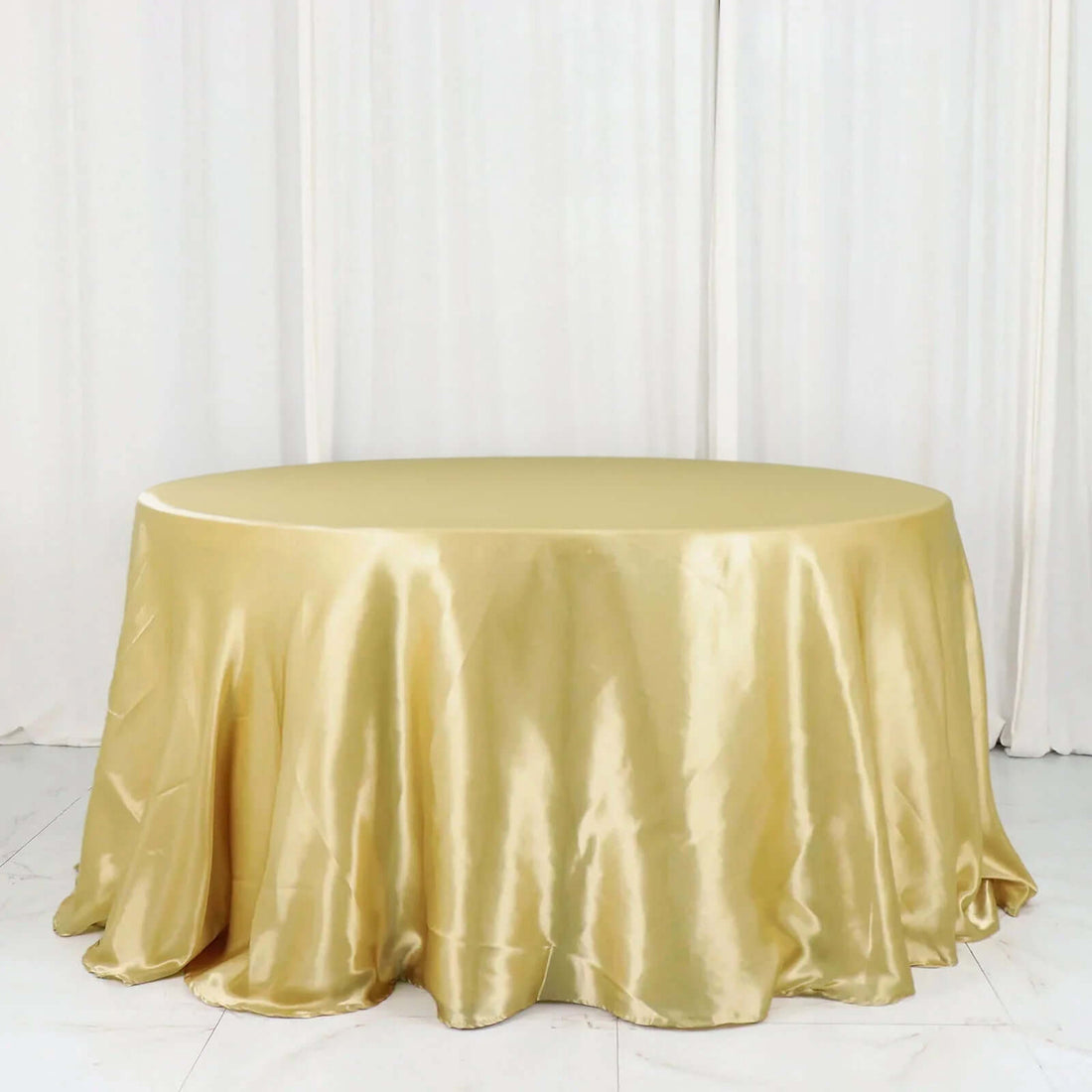 Gold satin tablecloth with elegant draping for events and decor.