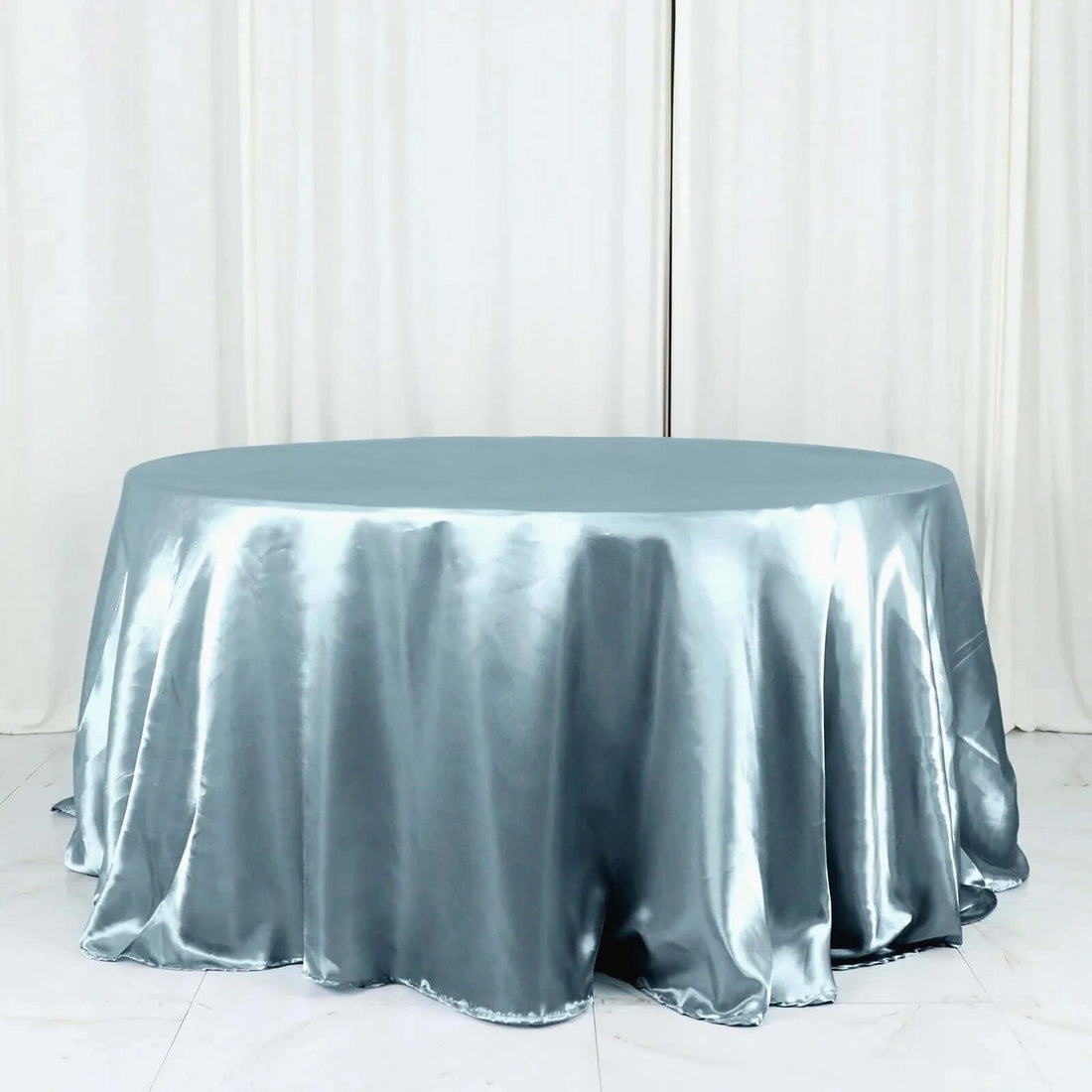 Round satin tablecloth in a soft blue shade, elegantly draped.