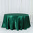 Green satin tablecloth on a round table against a white backdrop.