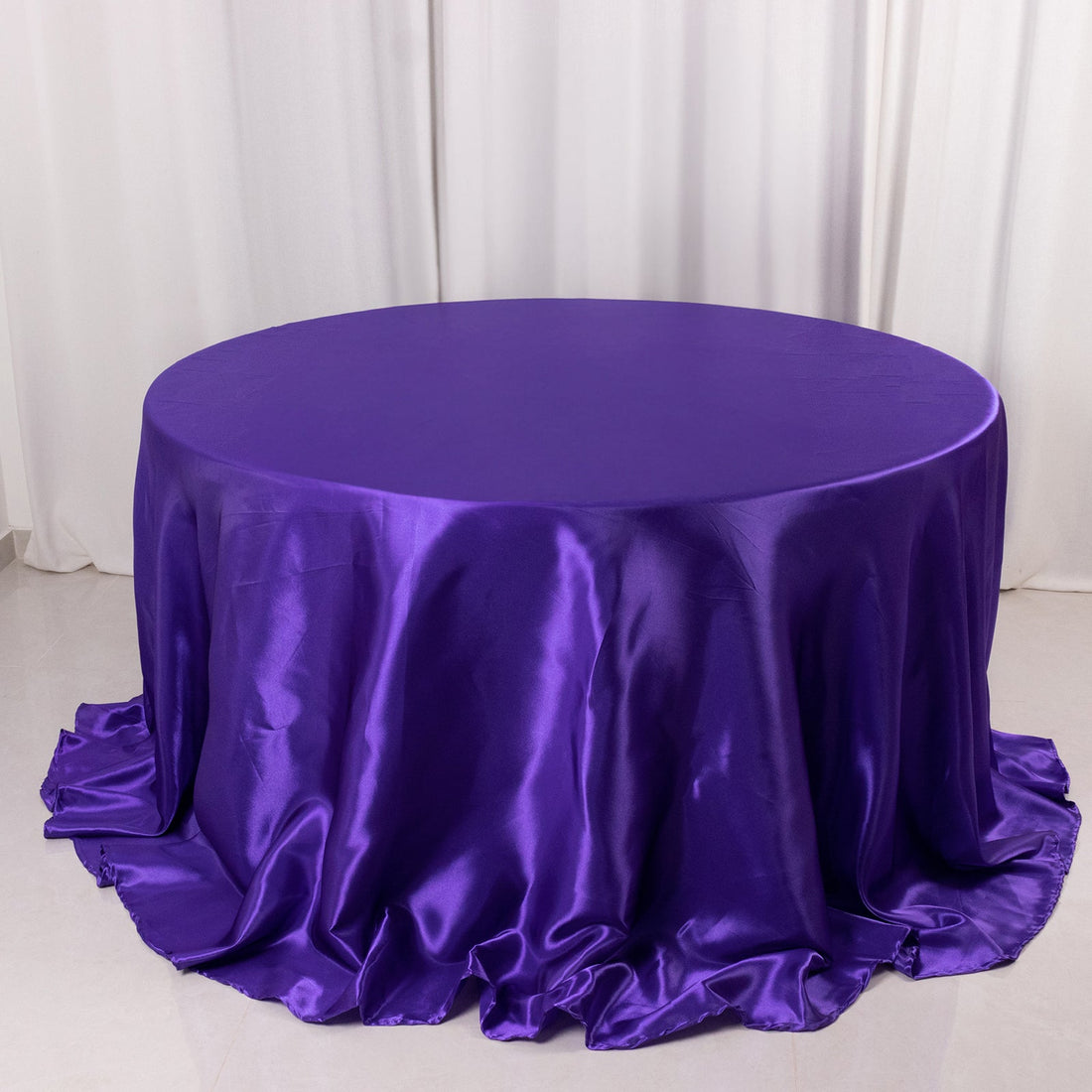 Purple satin tablecloth draped elegantly over a round table.