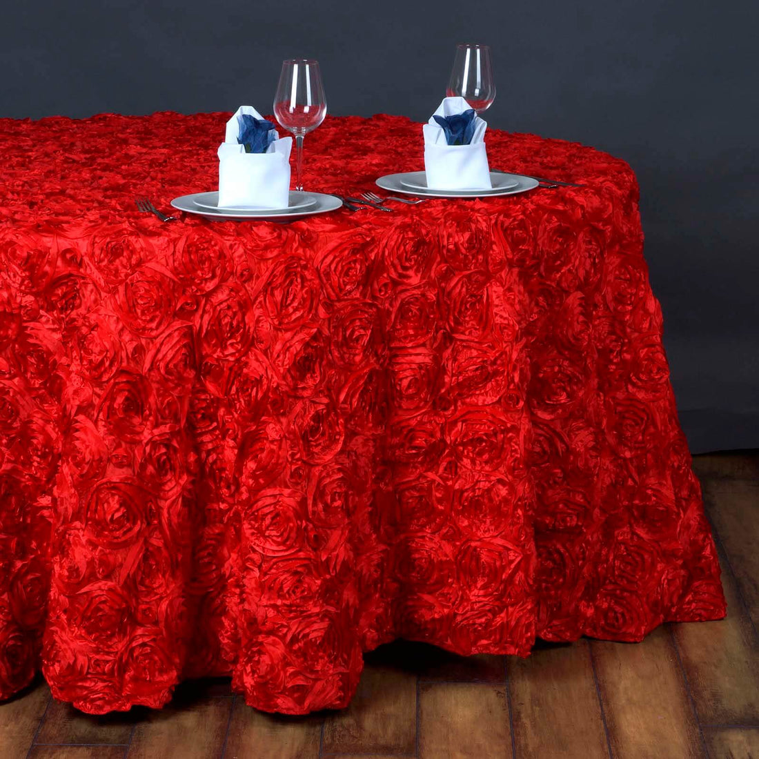 Red rose texture tablecloth with elegant dinner setting and glassware.