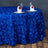 Elegant blue rose-pattern tablecloth on a dining table with glasses and napkins.