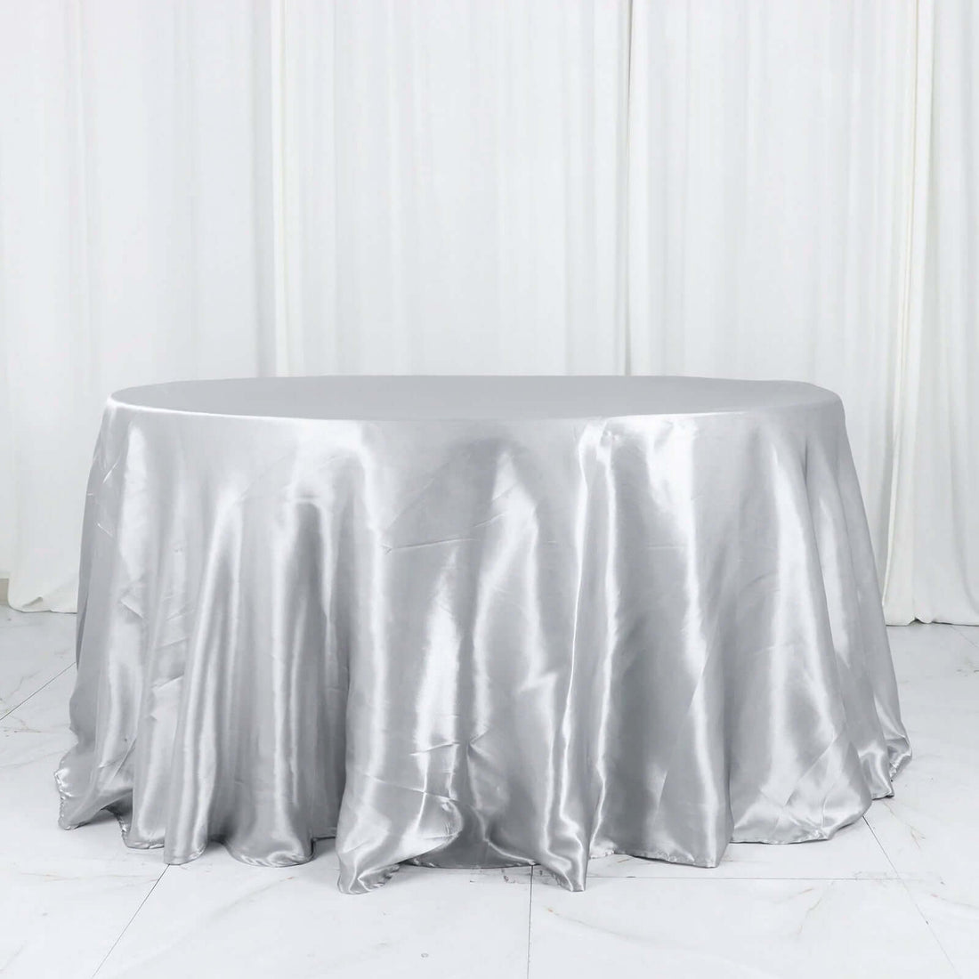 Silver tablecloth draped elegantly over a round table