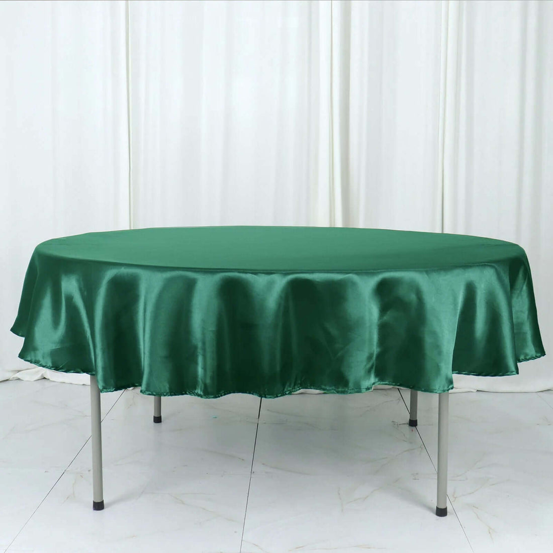 Green satin round tablecloth on a table