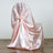 Pink satin chair cover draped elegantly over a chair.